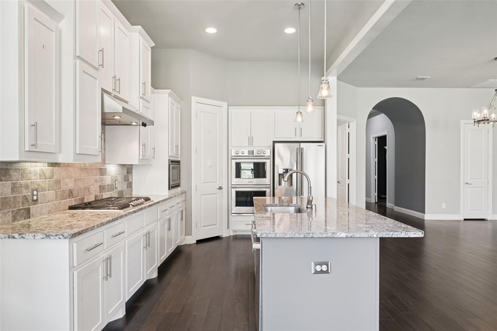 3415 Secretariat Place Celina, TX 75009 - Photo 32 of 40 a kitchen with stainless steel appliances granite countertop a sink refrigerator and cabinets