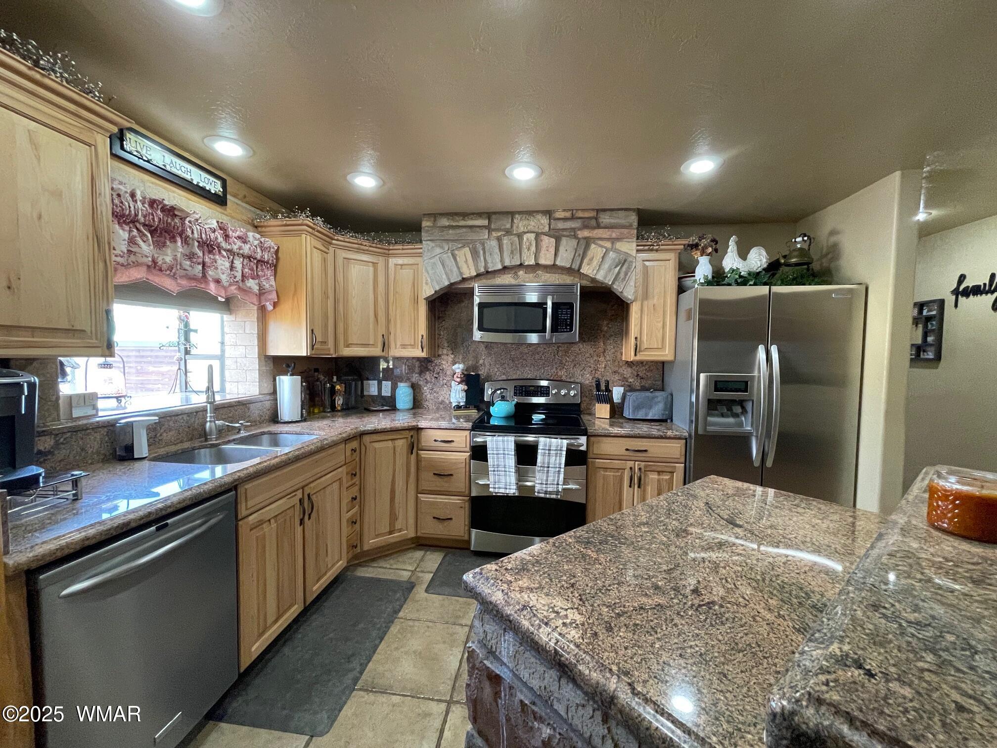 183 North Becker Lake Road Springerville, AZ 85938 - Photo 12 of 41 a kitchen with stainless steel appliances granite countertop a sink refrigerator stove microwave and cabinets