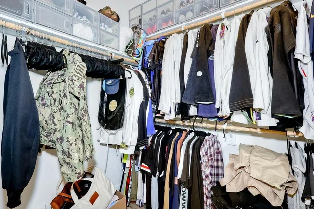a view of walk in closet with clothes and shoes