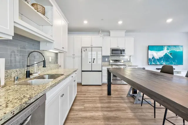 a kitchen with kitchen island granite countertop a sink appliances and cabinets