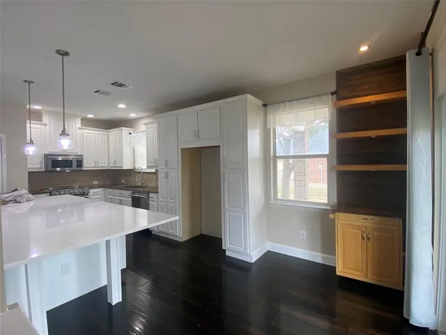 a kitchen with stainless steel appliances a refrigerator and a stove top oven