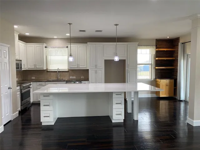 a kitchen with stainless steel appliances granite countertop a stove a refrigerator and a wooden cabinets