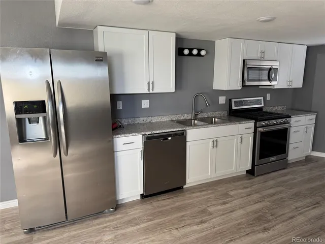 a kitchen with stainless steel appliances a refrigerator sink and microwave