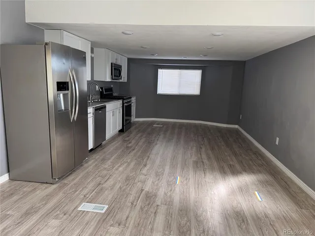 a view of kitchen with wooden floor electronic appliances and window