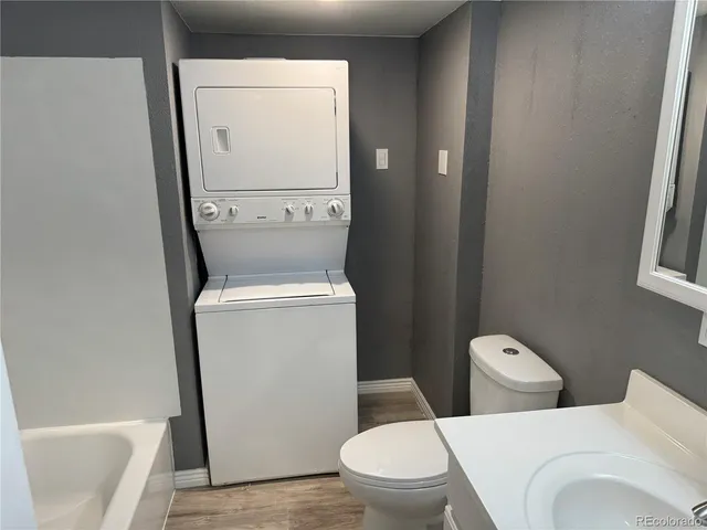 a white toilet sitting next to a white sink and vanity