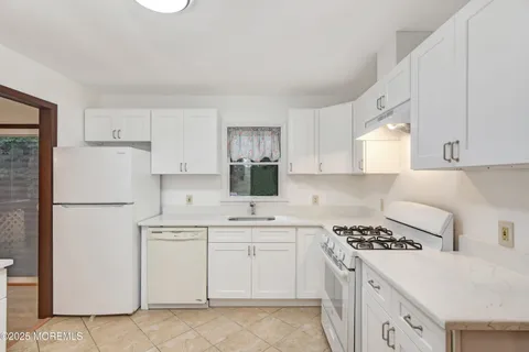 a kitchen with a white cabinets and white appliances