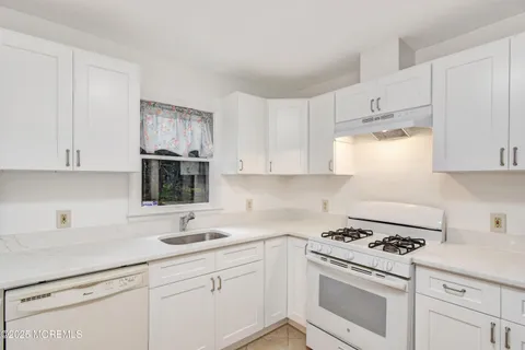 a kitchen with cabinets appliances a sink and a counter top