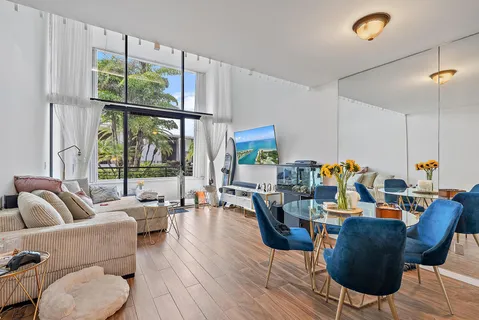 a living room with furniture a fireplace and a floor to ceiling window