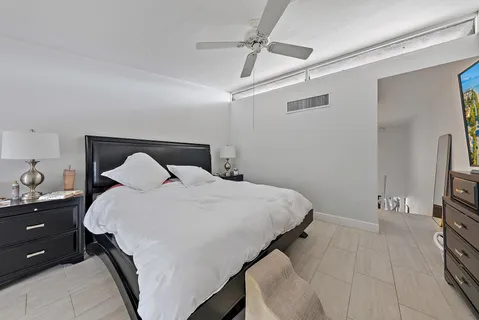 a bedroom with a bed and a flat tv screen on the dresser