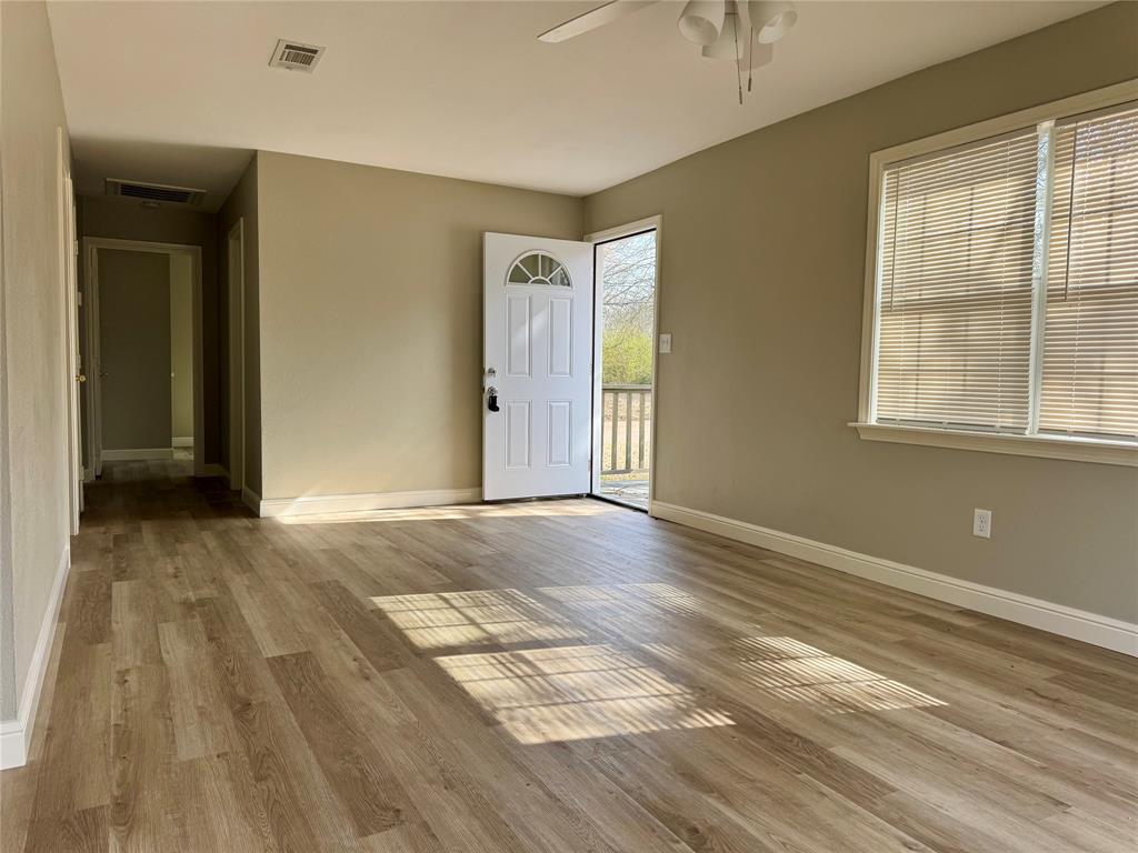 301 Fairview Street Pittsburg, TX 75686 - Photo 4 of 13 a view of an empty room with wooden floor and a window