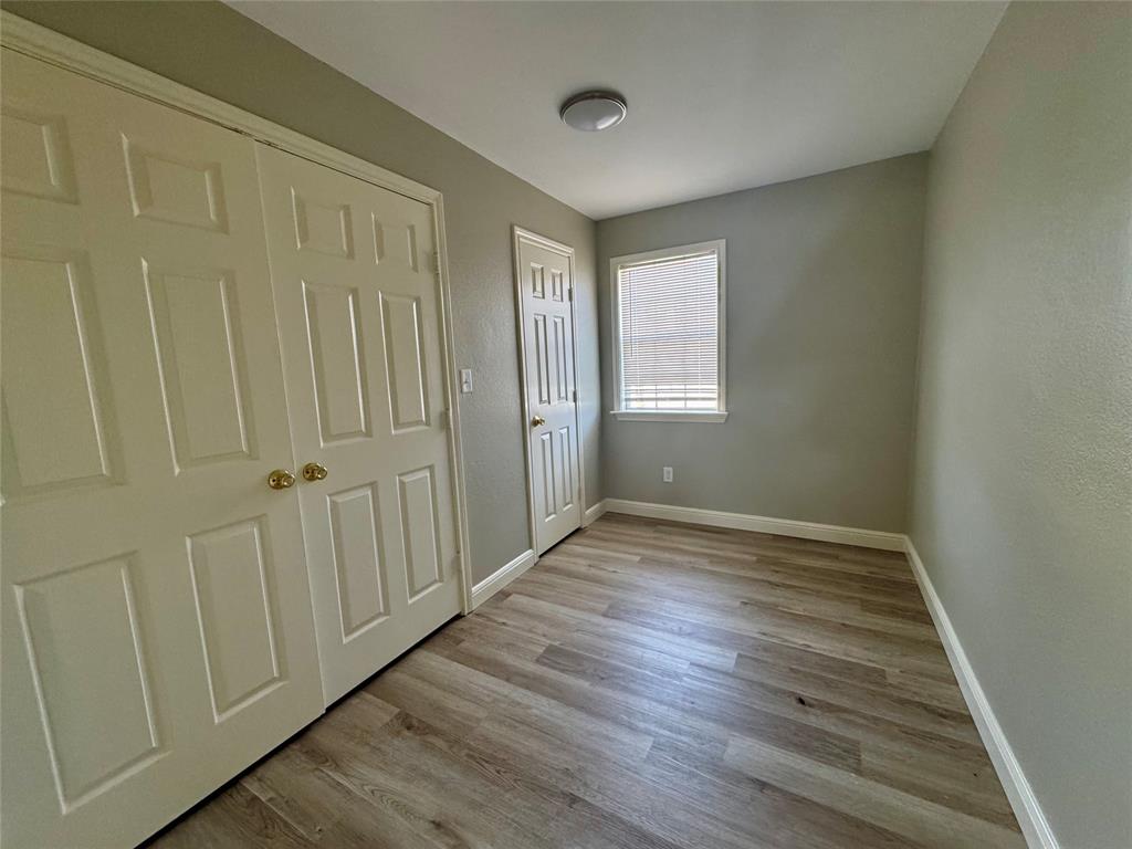 301 Fairview Street Pittsburg, TX 75686 - Photo 6 of 13 a view of an empty room with wooden floor and a window