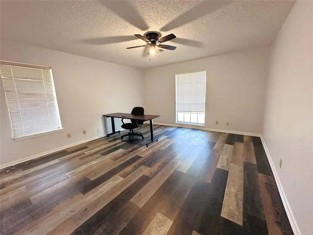 a view of wooden floor and a chandelier fan in a room