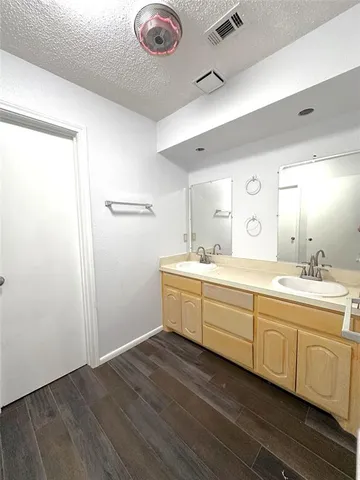 a bathroom with a double vanity sink and mirror with shower