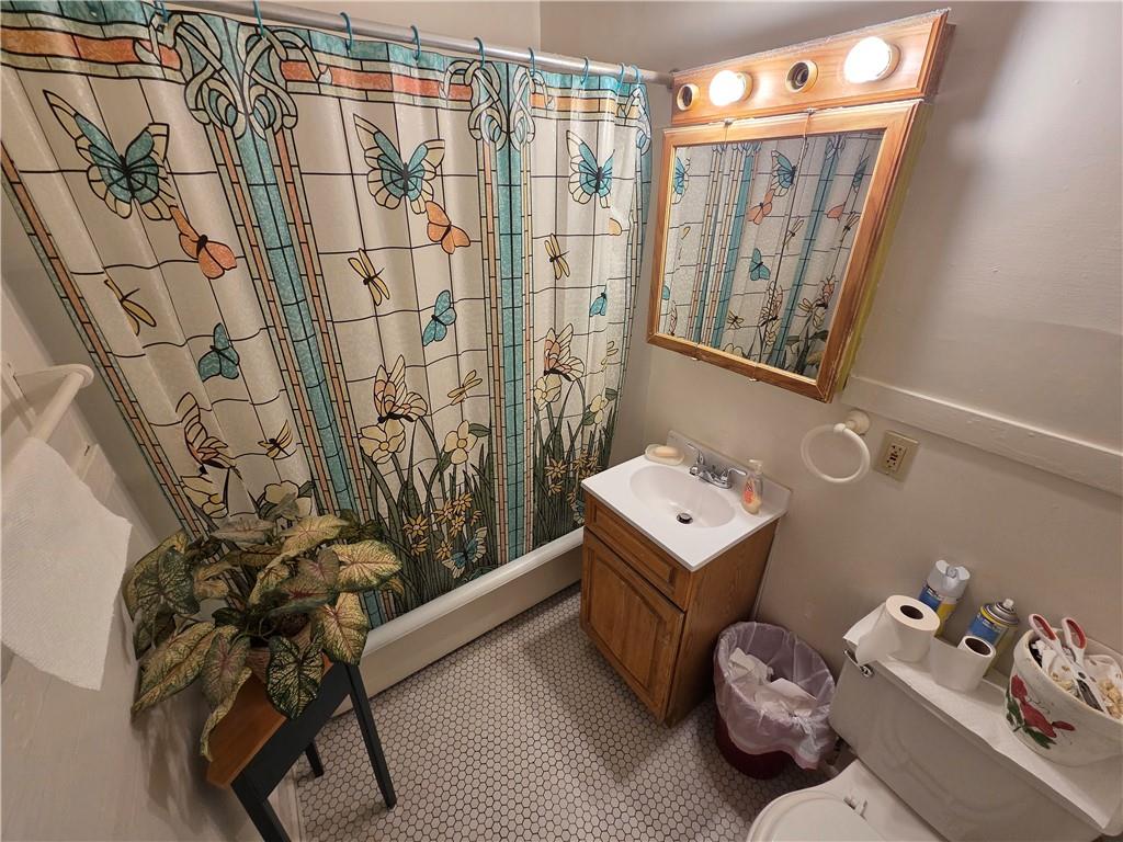 3520 Campus Street Pittsburgh, PA 15212 - Photo 12 of 26 a bathroom with a sink a toilet and shower curtain