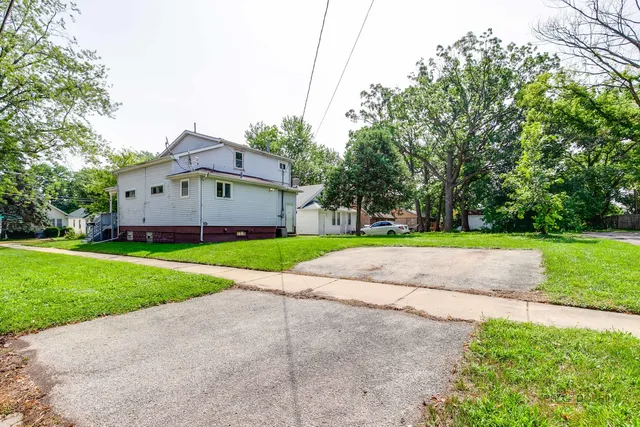 a front view of a house with a garden and yard