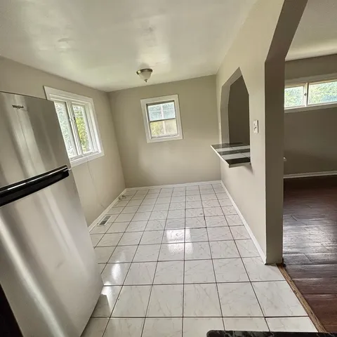 a view of a refrigerator in kitchen and a window