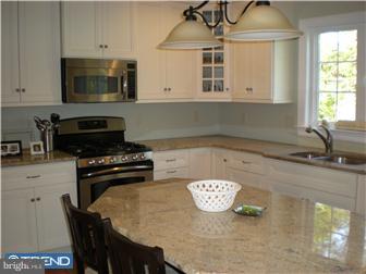 210 Middletown Road Media, PA 19063 - Photo 3 of 11 a kitchen with a stove a microwave and wooden cabinets