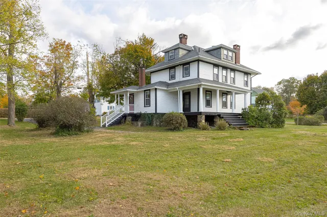a view of a house with a big yard and large trees