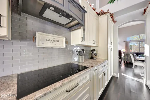 a kitchen with a sink a stove cabinets and wooden floor