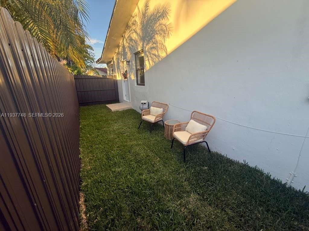 10785 Southwest 26th Street, Unit A Miami, FL 33175 - Photo 2 of 9 a backyard of a house with table and chairs