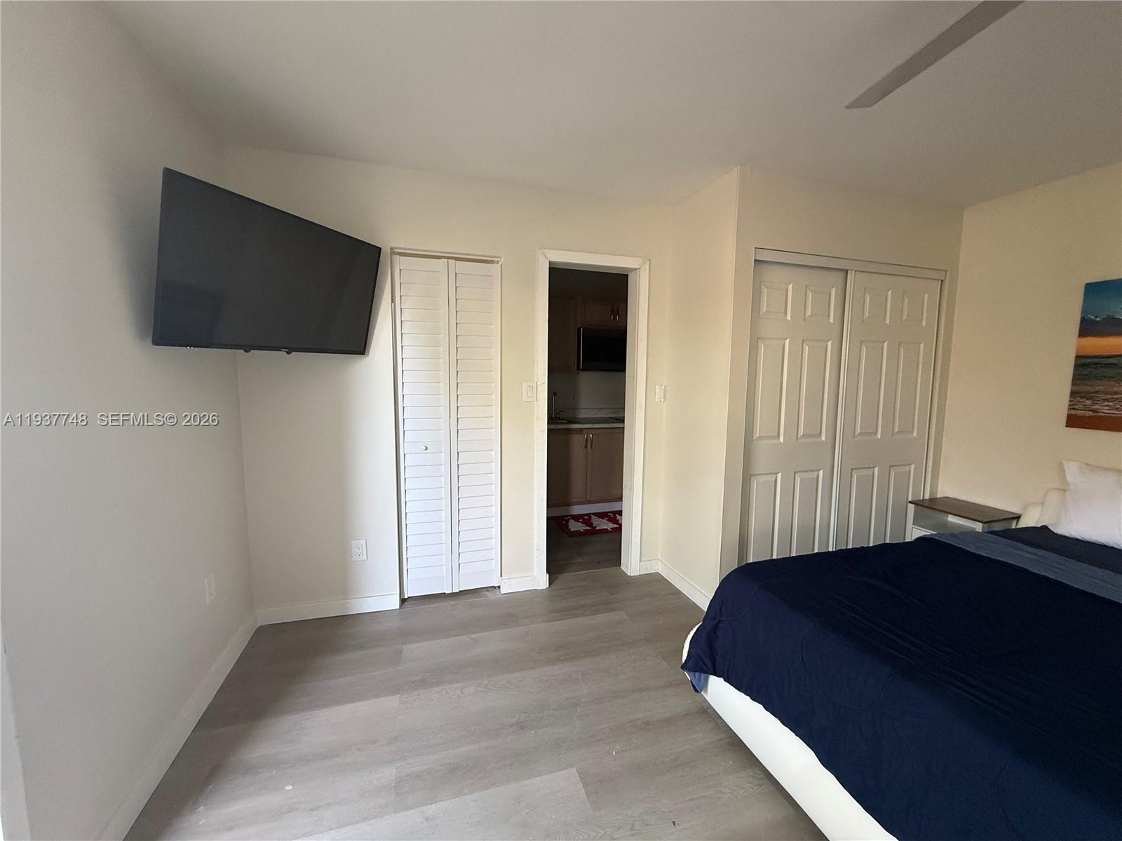 10785 Southwest 26th Street, Unit A Miami, FL 33175 - Photo 5 of 9 a bedroom with a bed and a flat screen tv