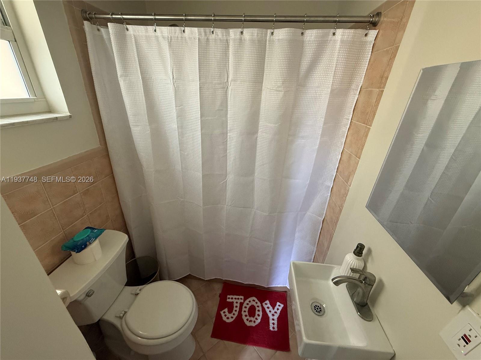 10785 Southwest 26th Street, Unit A Miami, FL 33175 - Photo 7 of 9 a white toilet sitting next to a sink