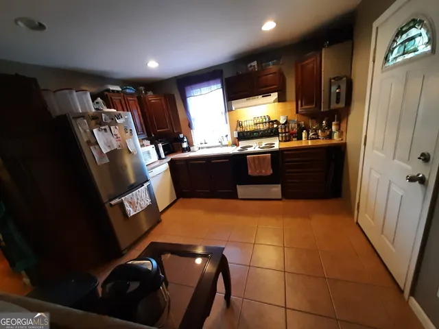 a large kitchen with stainless steel appliances granite countertop a stove a sink dishwasher and a refrigerator