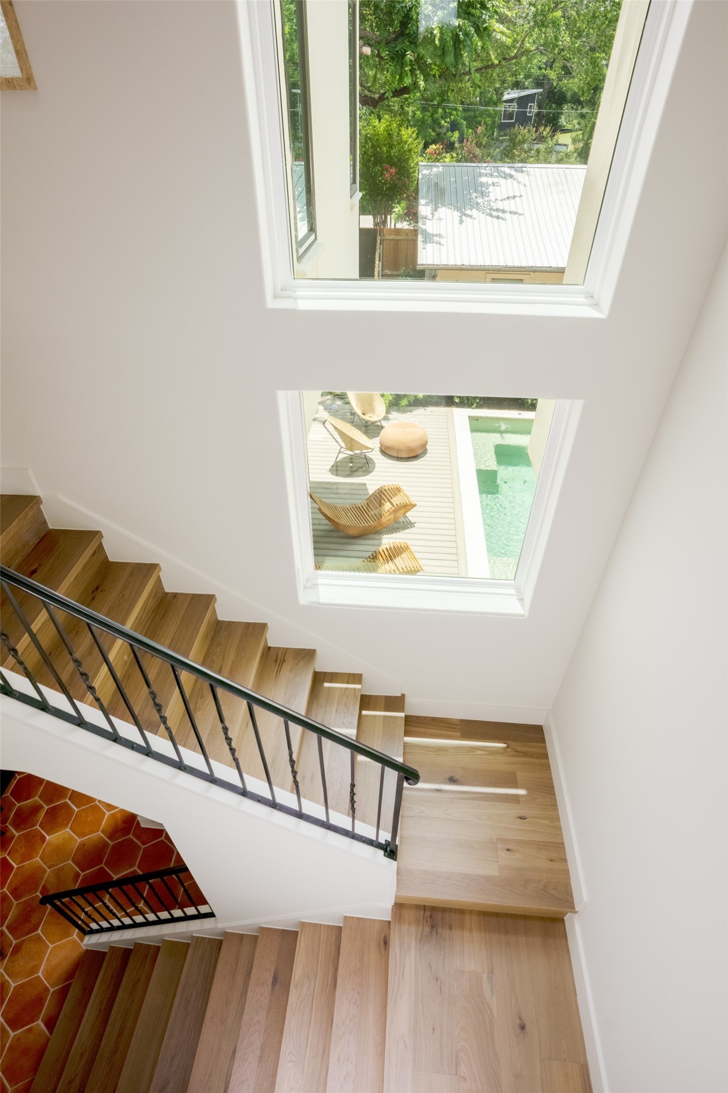 4713 Bolm Road Austin, TX 78702 - Photo 19 of 40 Staircase featuring wood-finish flooring and black metal balusters