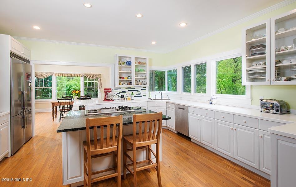 596 Riversville Road Greenwich, CT 06831 - Photo 13 of 24 a kitchen with a table chairs stove and cabinets