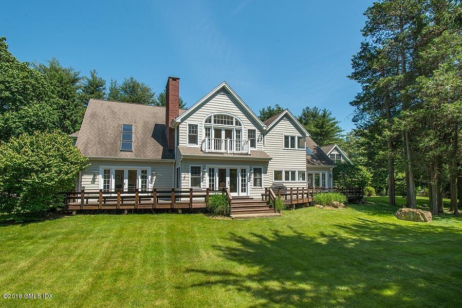 596 Riversville Road Greenwich, CT 06831 - Photo 5 of 24 a front view of a house with a yard table and chairs