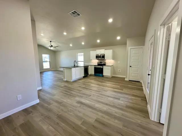 a view of a kitchen with a sink and a refrigerator