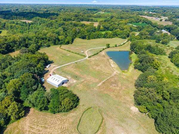 an aerial view of a house with a yard and lake view