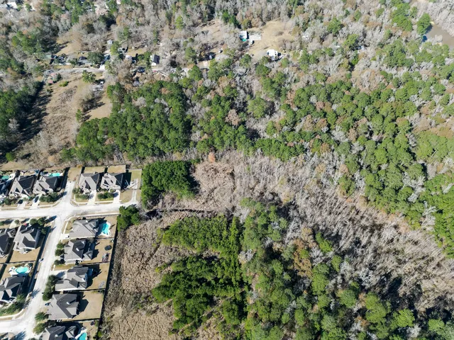 an aerial view of a house with a lush green forest