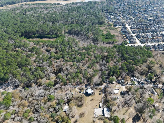 an aerial view of residential houses with outdoor space and trees