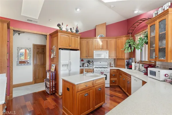 a kitchen with kitchen island granite countertop a sink stove and refrigerator