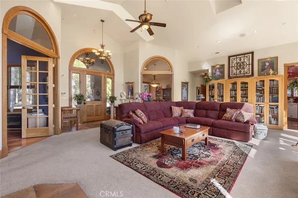 a living room with furniture chess floor and a chandelier