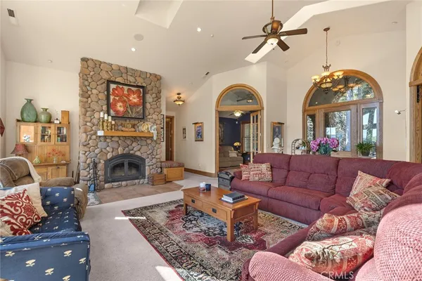 a living room with furniture a fireplace and a chandelier