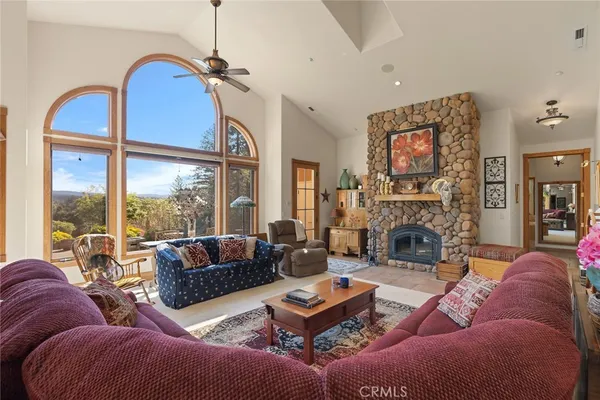 a living room with furniture a large window and a fireplace