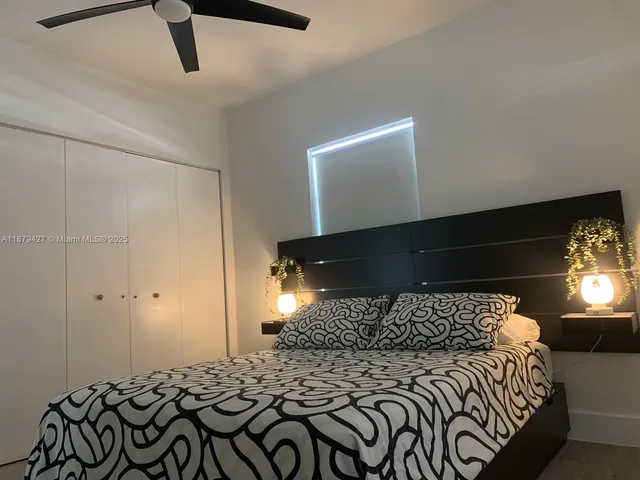 a bed sitting in a bedroom next to a lamp and a chandelier