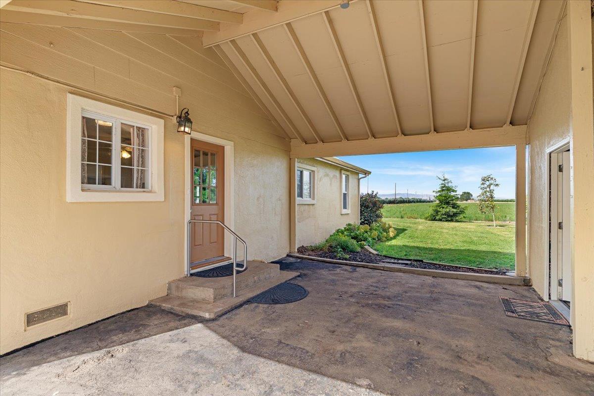 607 East Keyes Road Ceres, CA 95307 - Photo 16 of 46 property entrance with a patio area, a lawn, and stucco siding