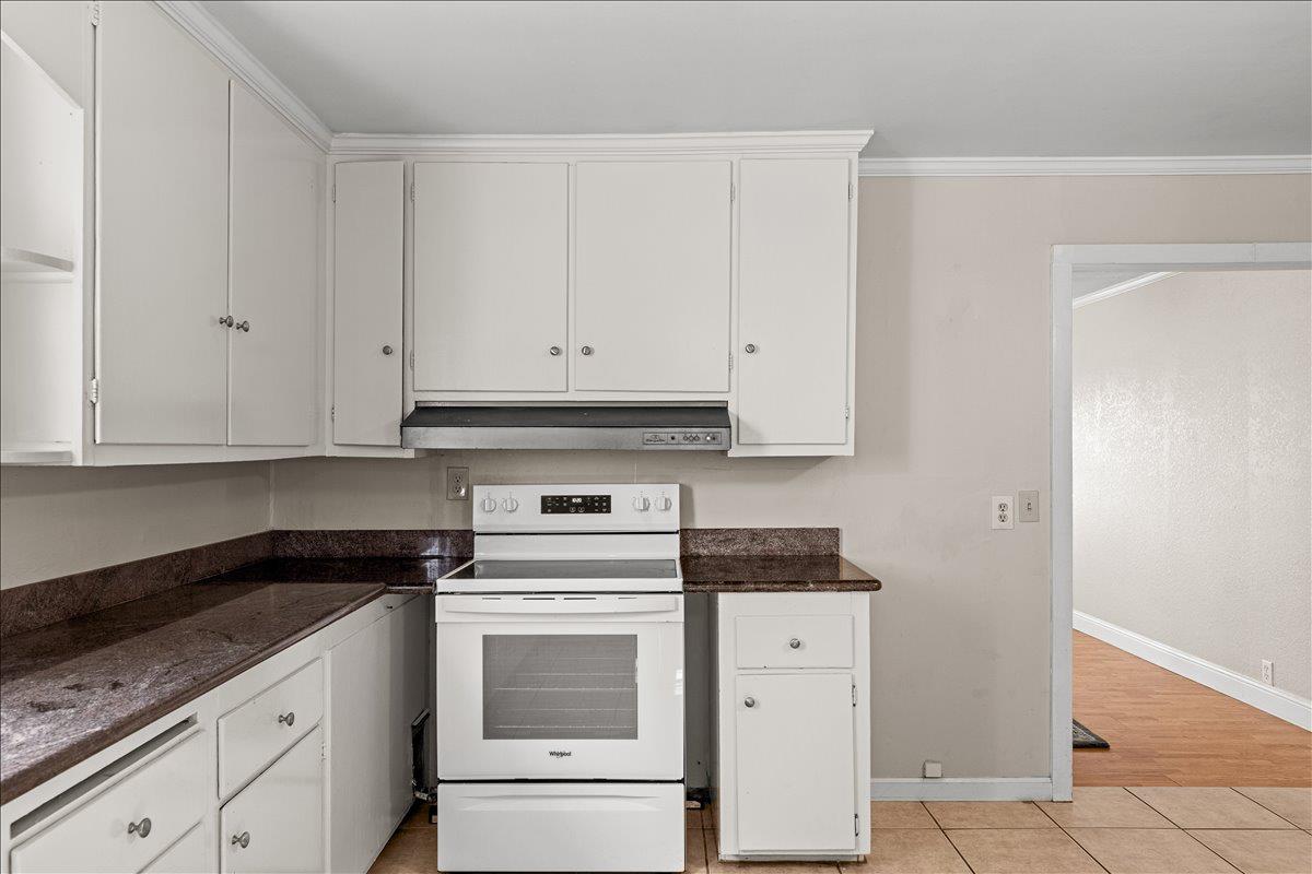 607 East Keyes Road Ceres, CA 95307 - Photo 18 of 46 kitchen with electric stove, white cabinets, dark countertops, and crown molding