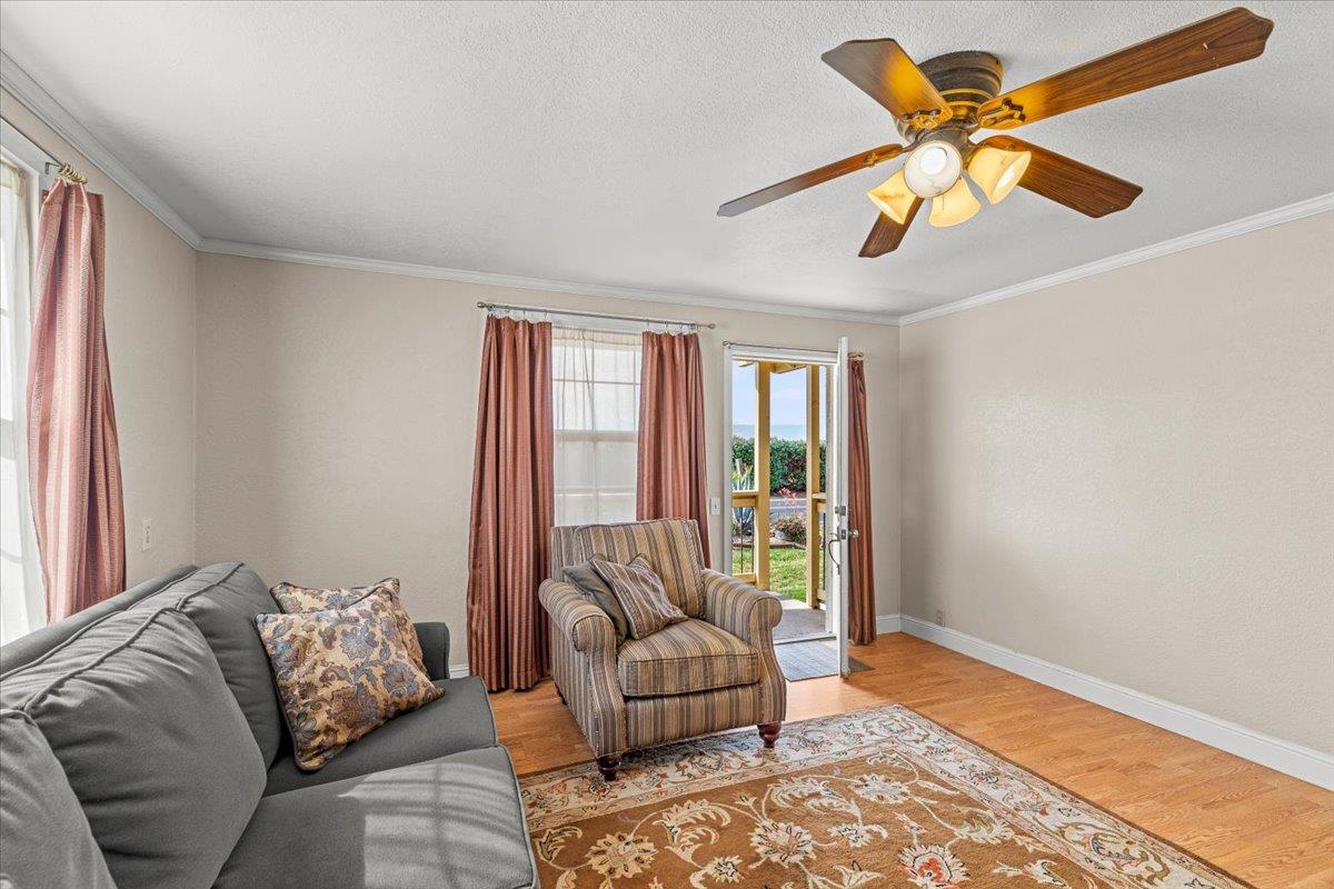607 East Keyes Road Ceres, CA 95307 - Photo 33 of 46 living area featuring light wood finished floors, a ceiling fan, crown molding, and a textured ceiling