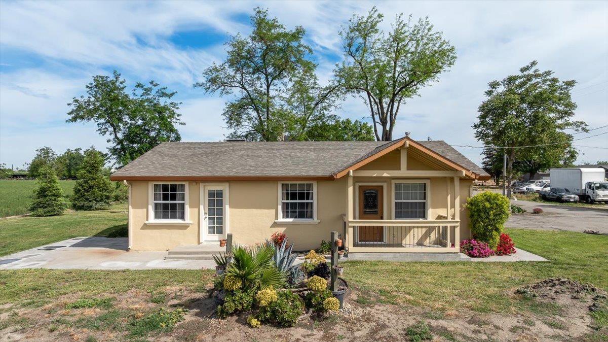 607 East Keyes Road Ceres, CA 95307 - Photo 38 of 46 view of front of home featuring a front lawn, stucco siding, roof with shingles, and covered porch