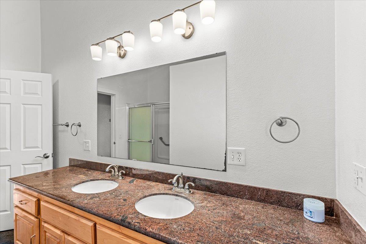 607 East Keyes Road Ceres, CA 95307 - Photo 4 of 46 bathroom with double vanity, a shower stall, and a textured wall