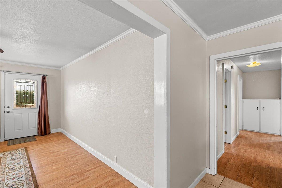 607 East Keyes Road Ceres, CA 95307 - Photo 5 of 46 foyer entrance featuring light wood-type flooring, crown molding, and a textured wall