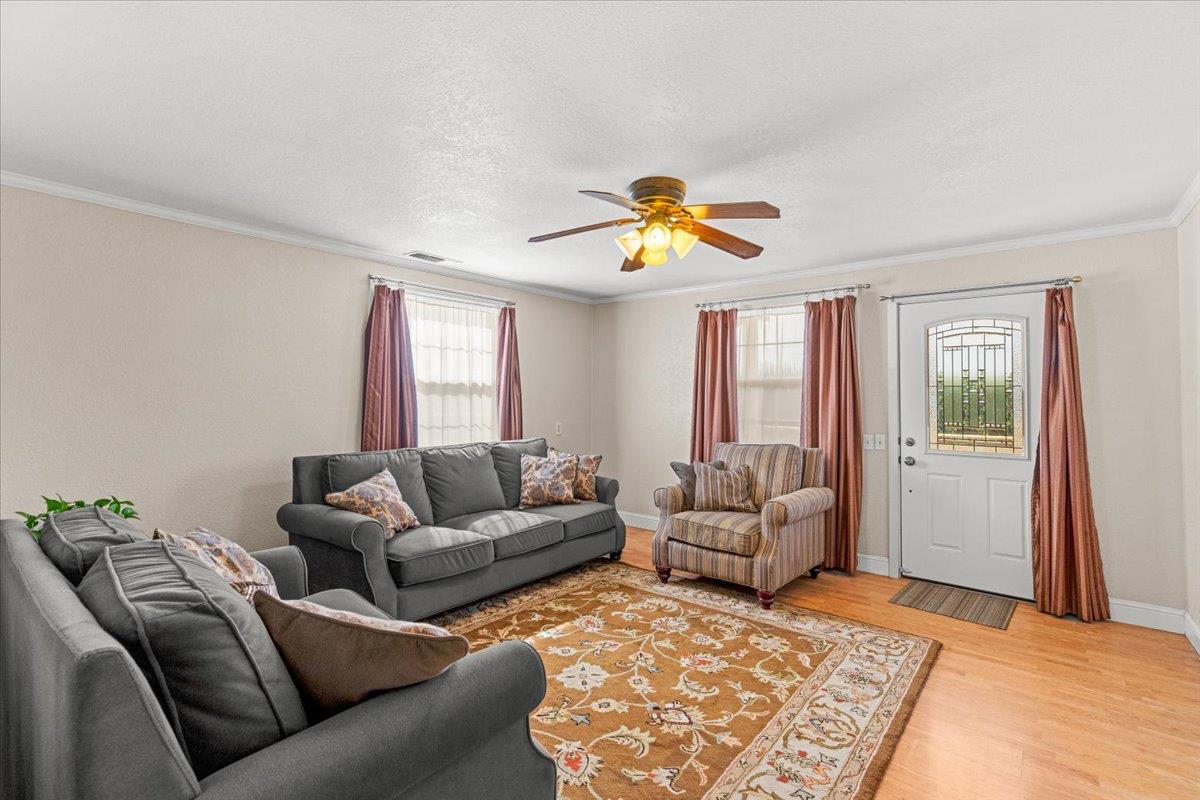 607 East Keyes Road Ceres, CA 95307 - Photo 8 of 46 living room with a ceiling fan, wood finished floors, and crown molding