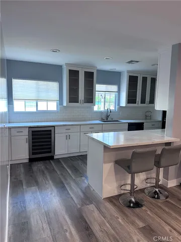 a view of a kitchen with kitchen island a sink and wooden floor