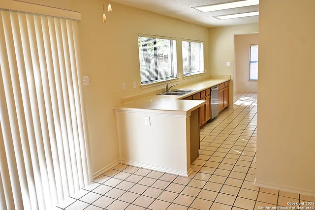 a kitchen with a sink a window and cabinets