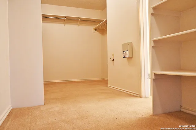 a view of an empty room with closet and a ceiling fan