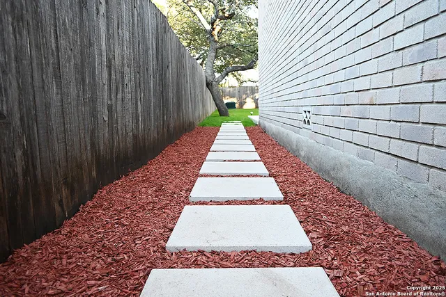 a view of a house with a yard and wooden fence